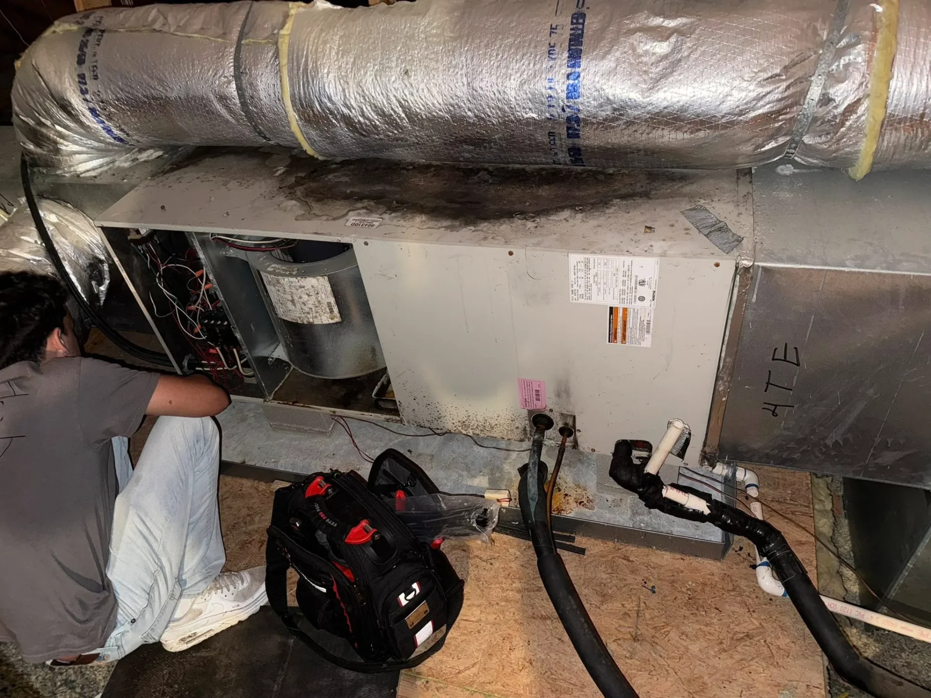 TMAC technician inspecting residential air handler unit